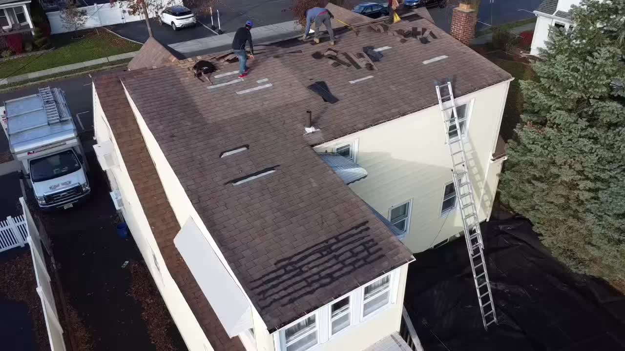 A&J crew tearing off old shingles, aerial view