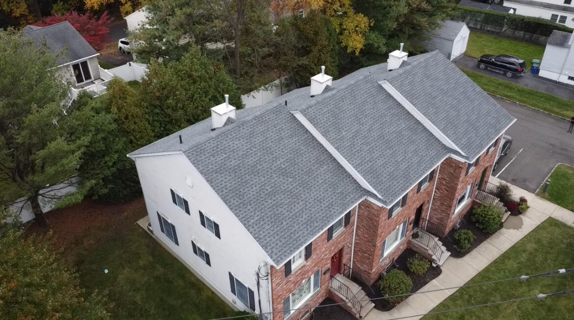Aerial view of a finished roof on a multi-family brick building