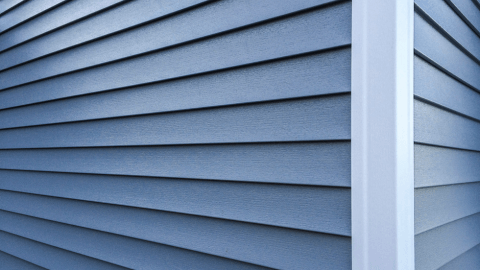 Close-up texture of finished blue-gray vinyl siding