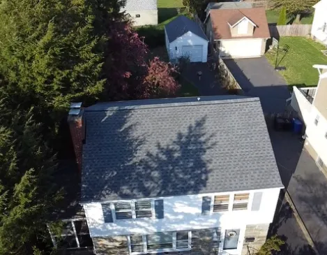 Aerial view of a completed shingle roof replacement on a two-story home