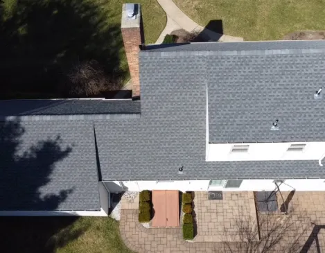 Aerial view of a completed shingle roof and chimney