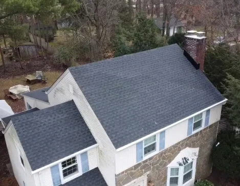 Aerial view of a finished roof on a stone-and-siding two-story home
