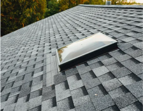 Close-up of new architectural shingles around a roof skylight