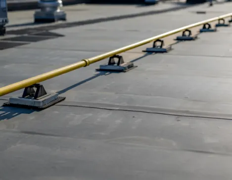 Close-up of a flat commercial roof safety line anchor system