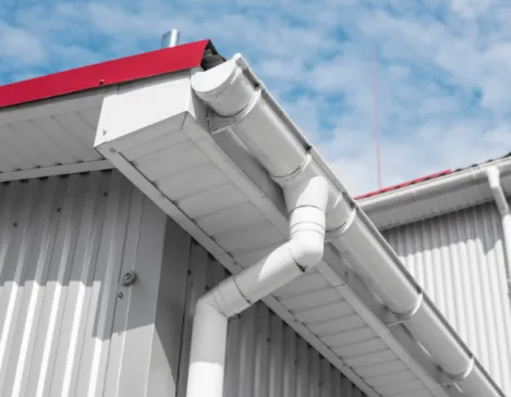Finished gutter and downspout on a commercial metal-sided building
