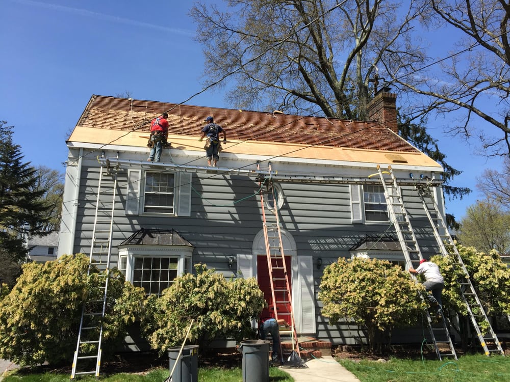 A&J crew on ladders working the roofline and gutters