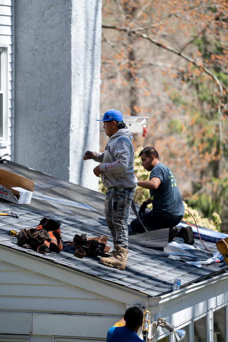 A&J crew installing asphalt shingles on a roof