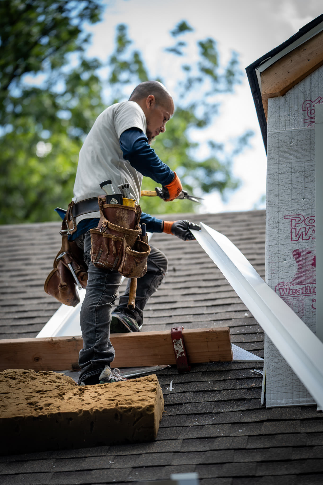 A&J crew installing a downspout section at the roof edge